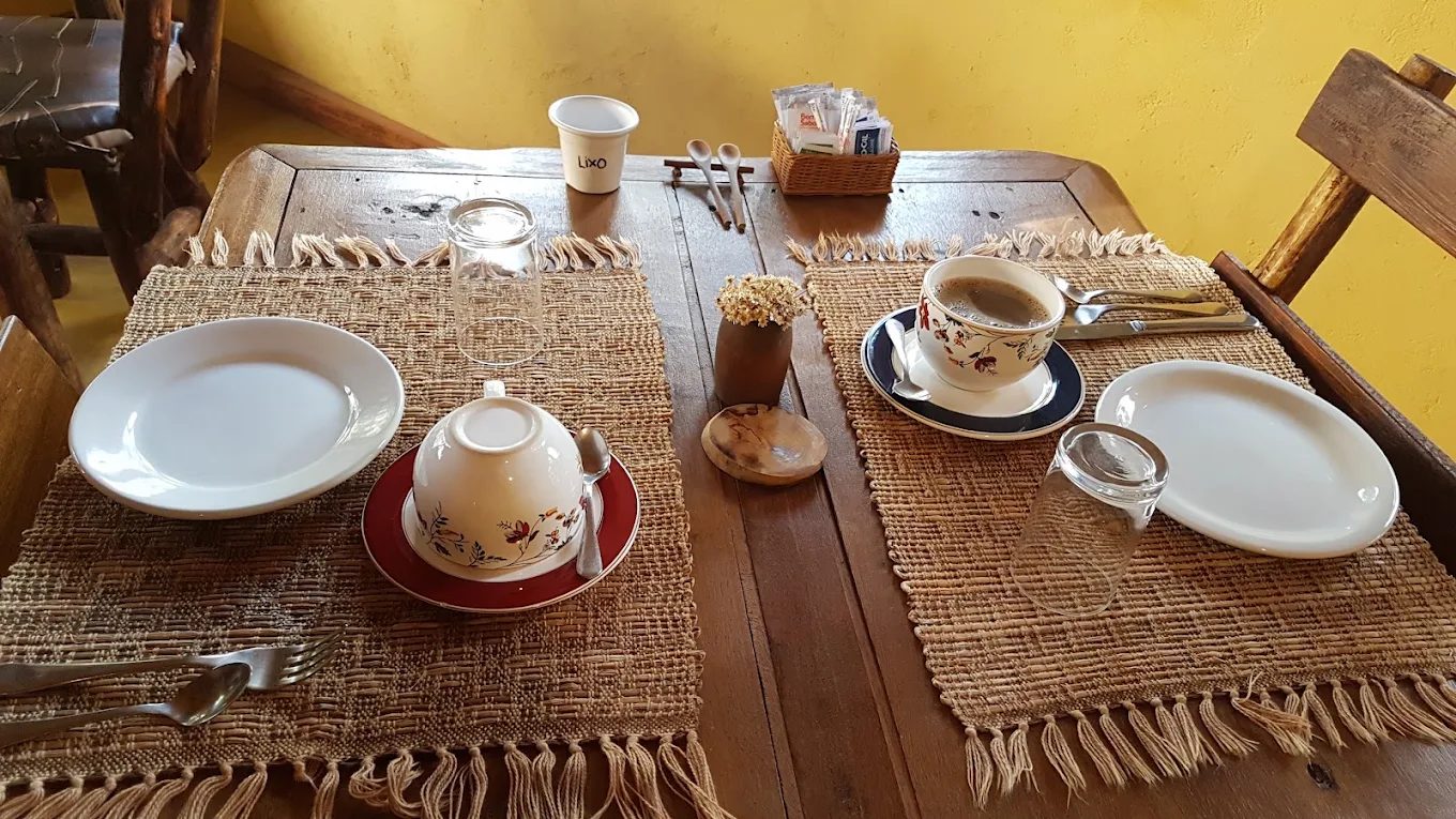 Mesa de madeira com jogo americano de fibra e xícaras